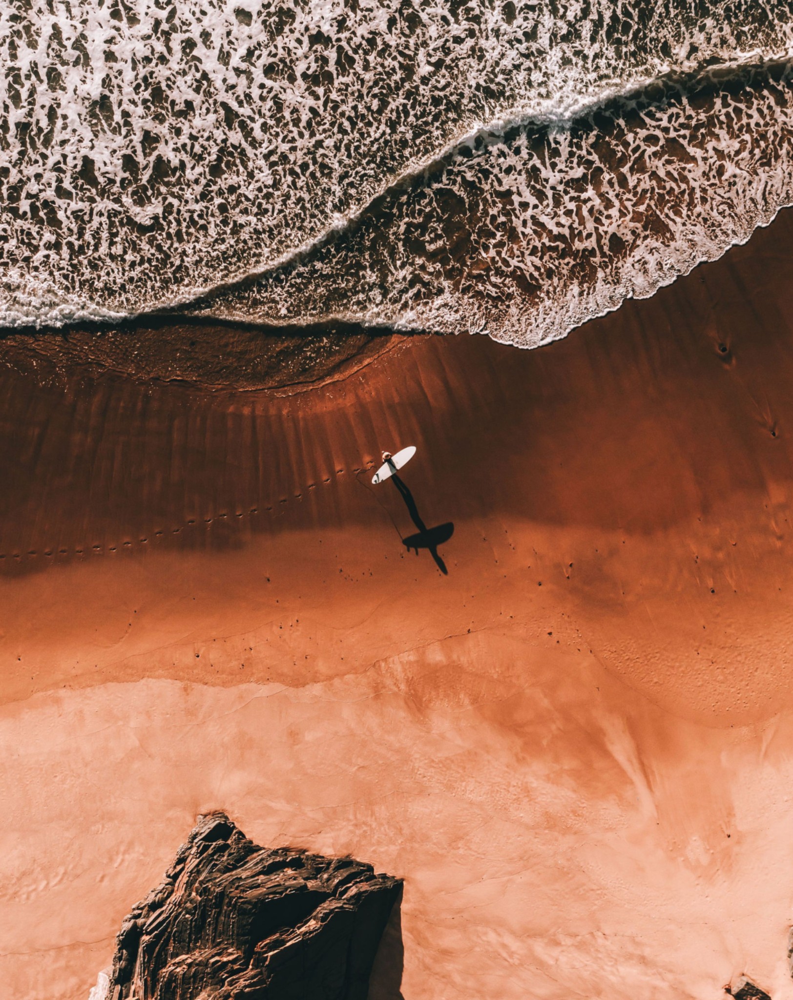 Ocean wave meeting warm sand from above
